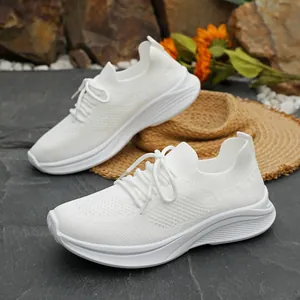 Detaillierte Nahaufnahme weißer Fly-Knit-Plateau-Sneaker mit dicker strukturierter Sohle.