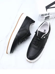Close-up detail of black perforated head layer cowhide leather sneakers with white soles