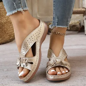 Close-up of champagne gold wedge sandals featuring intricate laser-cut hollow flower details.