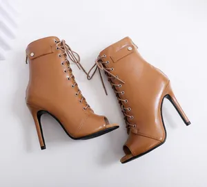 Close-up of elegant tan lace-up peep-toe stiletto boots designed for jazz dance performance