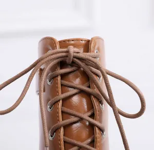 Close-up detail of high-quality brown leather lacing on stylish women's open toe dance boots