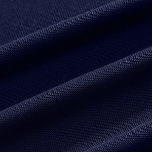 Macro detail of navy blue breathable quick-dry mesh fabric texture for men polo shirts.