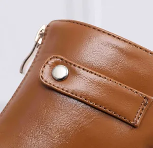 Macro close-up showing the premium brown leather texture and silver zipper of the boot
