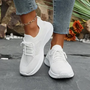 Detailansicht weißer Damen-Fly-Knit-Sneaker mit Plateausohle und Schnürung im Außenbereich