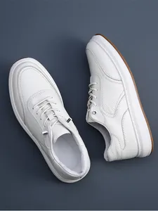 Top-down view of men's white premium leather casual sneakers with textured finish.