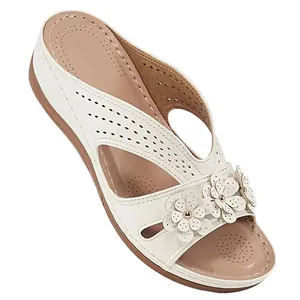 Elegant women's white platform wedge sandals featuring laser-cut patterns and floral decor