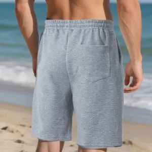 Close-up of grey jacquard textured men's shorts with a back pocket on the beach