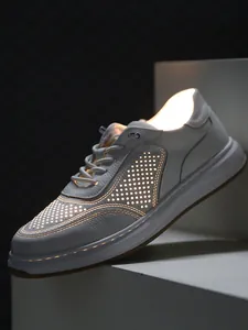 Close-up of breathable perforated white leather sneakers with artistic backlighting