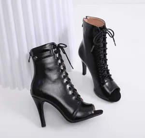 Close-up detail of stylish black peep-toe lace-up stiletto high-heel boots for women