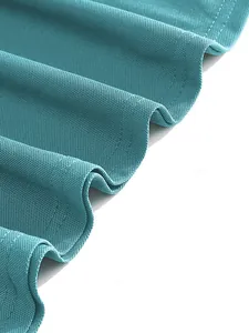Detailed close-up of breathable teal piqué fabric texture on a casual polo shirt