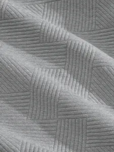 Close-up detail of grey heavyweight jacquard fabric with textured 3D grid pattern.