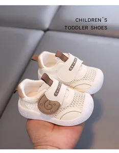 Close-up of white breathable mesh toddler shoes with brown velcro strap and soft sole