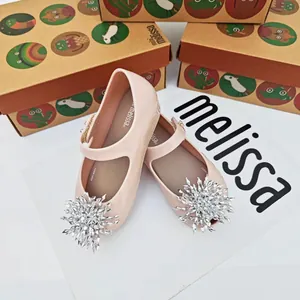 Vista detallada de los zapatos jelly rosas para niños con un adorno de cristal de copo de nieve.