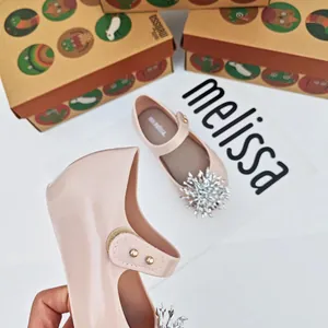 Vista detallada de zapatos de gelatina rosas para niña con adorno de copo de nieve de strass.