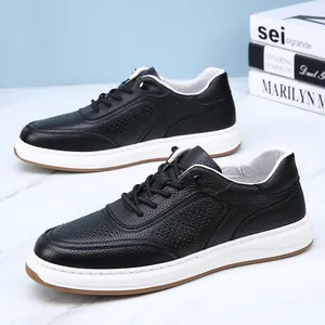 Detailed view of black perforated leather sneakers with white soles for men