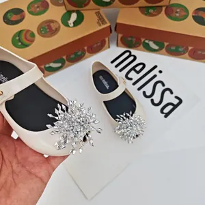 Vista detallada de zapatos de gelatina blancos para niñas con copo de nieve plateado