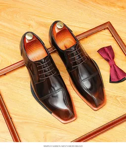 Top view of shiny brown men's chisel toe derby shoes with decorative wooden frame and red bow tie