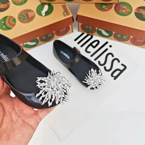 Primer plano de los zapatos de gelatina negros Melissa con un gran copo de nieve de cristal