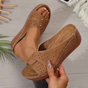Gedetailleerde opname van bruine damesplatform sandalen met sleehak en lasergesneden gaten