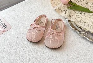 Primer plano de zapatos de princesa rosa de malla transpirable con lazo para niñas pequeñas