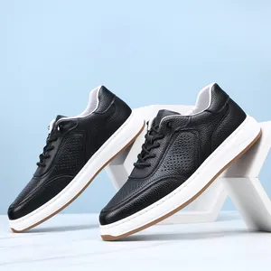 Close-up of black perforated leather men's sneakers with white soles on geometric props.