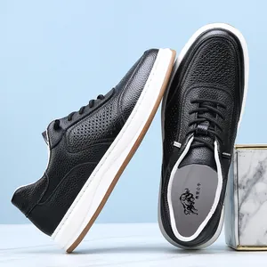 Macro view of black pebble-grain leather texture and perforated details on sneakers