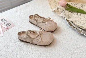 Detalle de zapatos de princesa de malla beige para niña con lazo en entorno real