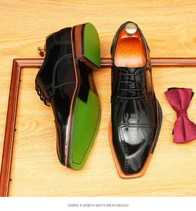 Macro view of glossy black blade-toe Derby shoes with orange and green accent soles
