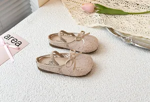 Detalle de sandalias de malla para niñas con bordado floral y lazo decorativo