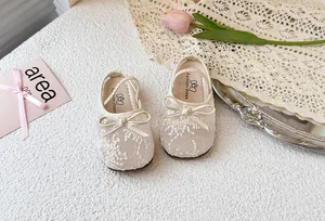 Vista detallada de zapatos de princesa para niña en malla con lazo y diseño de encaje