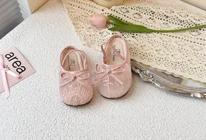 Detalle de zapatos de princesa de malla rosa para niña con un lazo y bordados finos