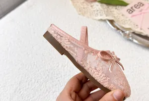 Primer plano de zuecos de princesa de encaje rosa para niñas con bordado floral