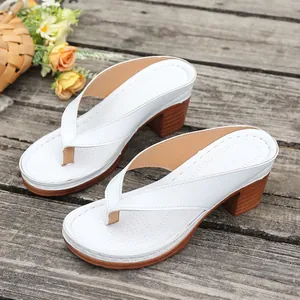 Detailed view of white thick high heel thong sandals on a rustic wooden background