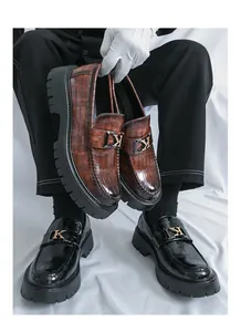 Macro view of premium men's platform crocodile pattern loafers with metal K buckle