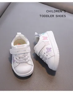 Macro detail of white leather toddler shoes featuring colorful butterfly embroidery