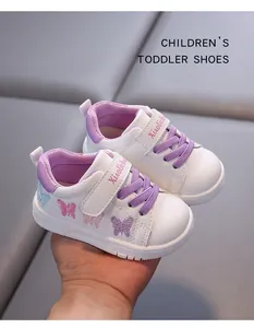 Detailed view of butterfly embroidery on white leather toddler shoes for baby girls