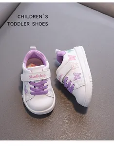 Close-up of toddler girls' white leather walking shoes with purple butterfly embroidery detail.