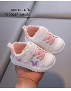 Detail view of white toddler shoes with pink butterfly embroidery and laces