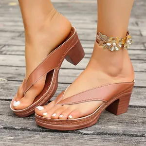 Close-up of brown block heel platform thong sandals worn on model on wooden deck