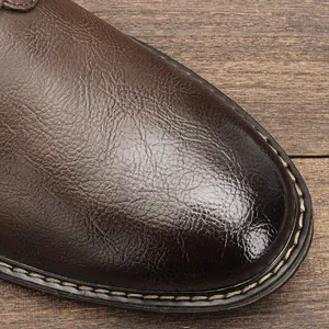 Macro view of brown leather men's dress shoe highlighting texture and stitching detail