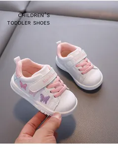 Close-up of white toddler sneaker featuring pink laces and elegant purple butterfly embroidery