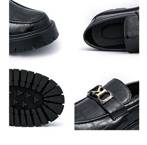 Detail view of men's black crocodile loafers with thick lug sole and gold buckle