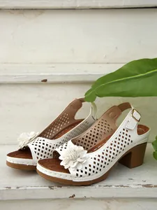 Detailansicht der weißen Sandalen mit Blockabsatz, Lochmuster und Blumendekoration