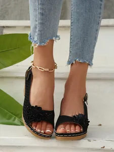 Detailansicht der schwarzen floralen Peeptoe-Sandalen mit elegantem Ausschnitt.