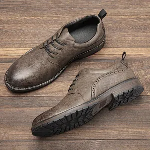 Detail view of textured grey-brown men's leather shoes with thick rubber sole.