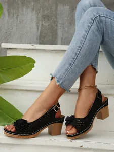 Elegante schwarze Sandalen mit Blockabsatz, Laserschnitt-Muster und Blumen-Applikation