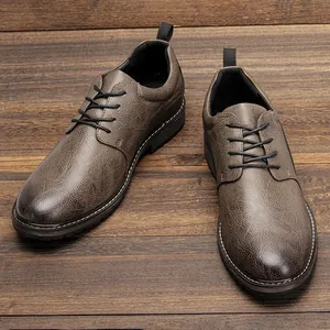 Detailed view of men's brown burnished leather dress shoes on wooden background.