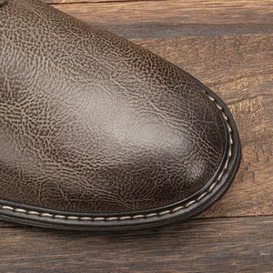 Macro detail of distressed brown leather shoe toe with fine stitching and natural texture