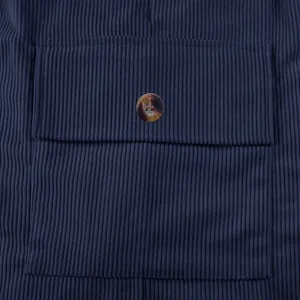 Dettaglio macro in tessuto di velluto a coste blu navy con patta classica con bottone