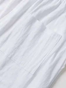 Close-up detail of white cotton linen fabric texture and pocket on men's casual pants